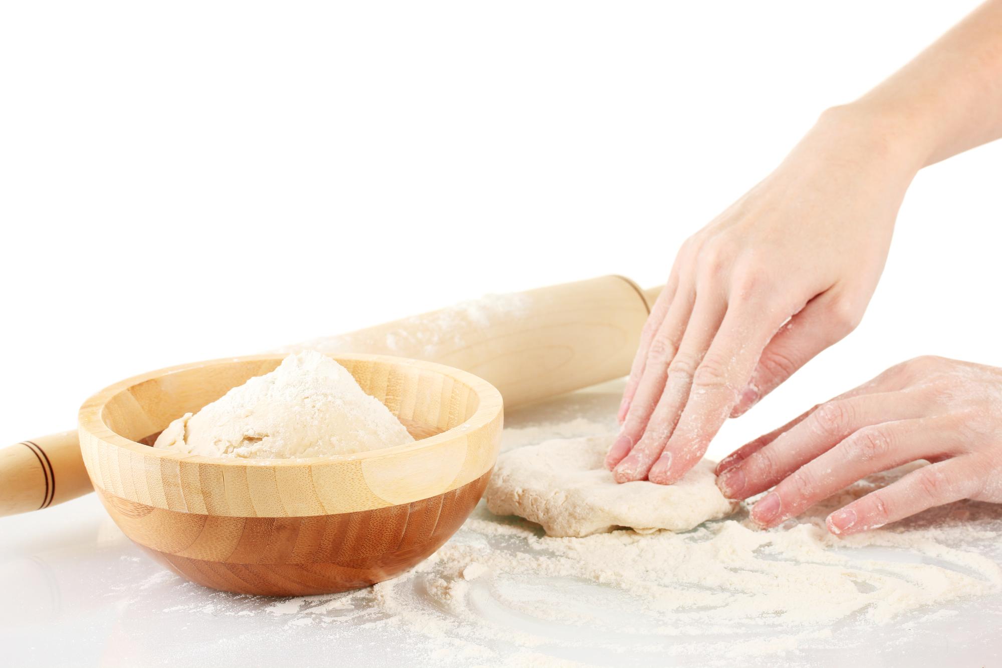 Hands kneading dough in natural light